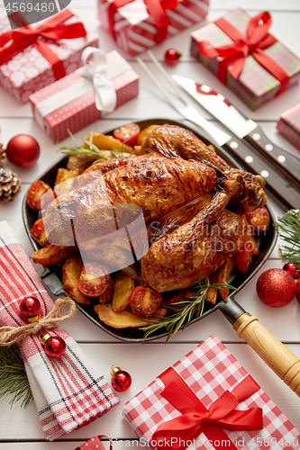 Image of Roasted whole chicken or turkey served in iron pan with Christmas decoration