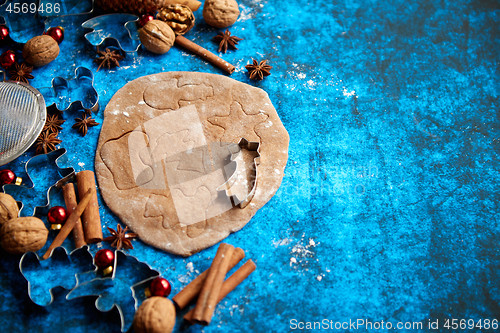 Image of Christmas baking concept. Gingerbread dough with different cutter shapes