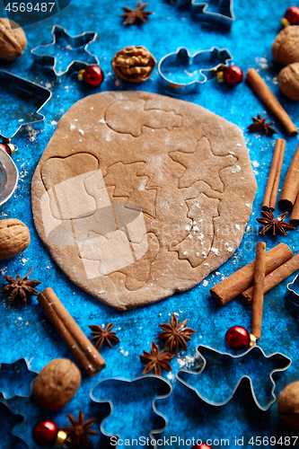 Image of Christmas baking concept. Gingerbread dough with different cutter shapes