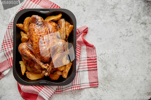 Image of Roasted chicken or turkey with potatoes in black steel mold