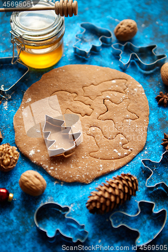 Image of Christmas baking concept. Gingerbread dough with different cutter shapes