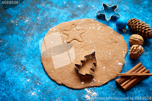 Image of Christmas baking concept. Gingerbread dough with different cutter shapes