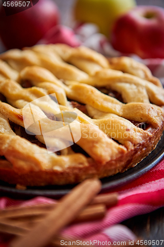 Image of Homemade pastry apple pie with bakery products on dark wooden kitchen table