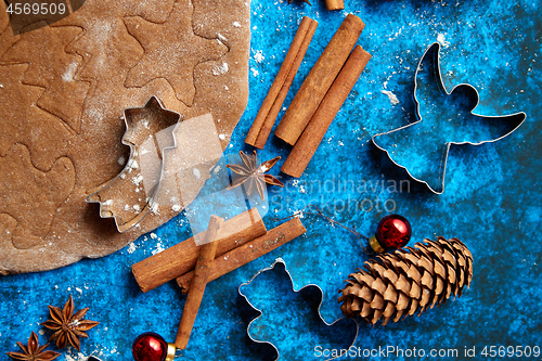 Image of Christmas baking concept. Gingerbread dough with different cutter shapes