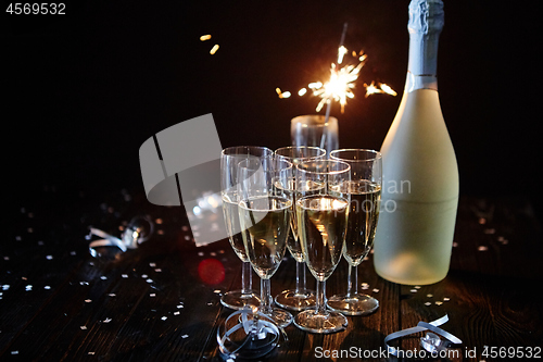 Image of Party composition image. Glasses filled with champagne placed on black table