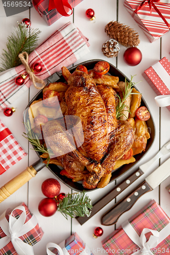 Image of Roasted whole chicken or turkey served in iron pan with Christmas decoration