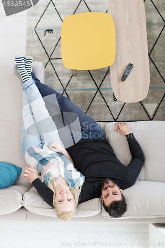 Image of Young couple on the sofa watching television top view