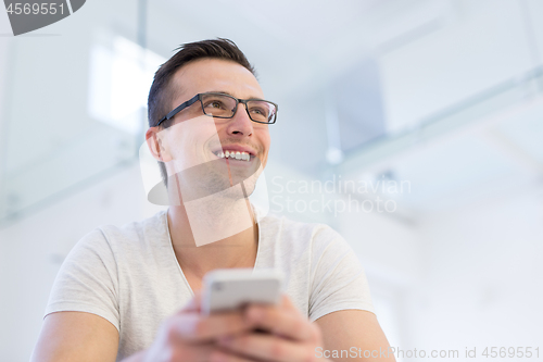 Image of young man using a mobile phone  at home