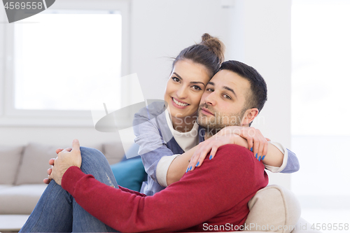 Image of couple hugging and relaxing on sofa