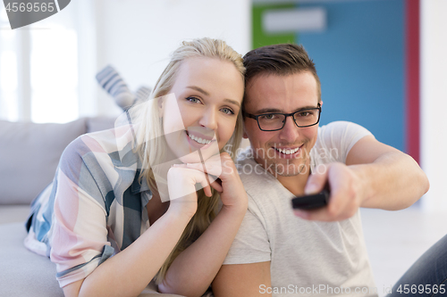 Image of Young couple on the sofa watching television