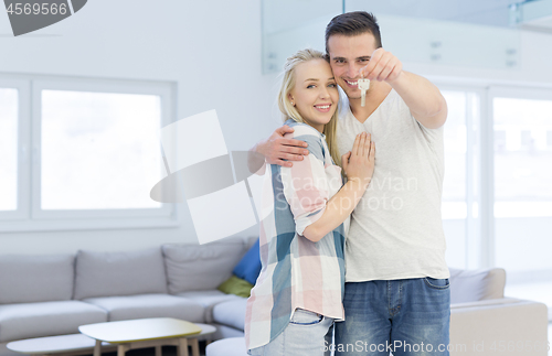 Image of couple showing a keys of their new house