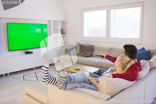 Image of Young couple on the sofa watching television