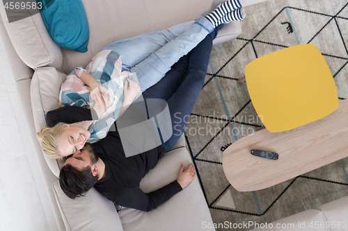 Image of Young couple on the sofa watching television top view