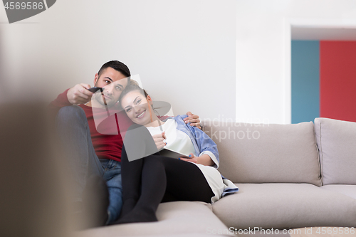 Image of Young couple on the sofa watching television