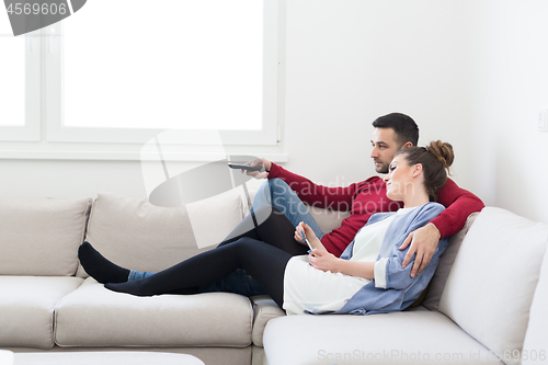 Image of Young couple on the sofa watching television