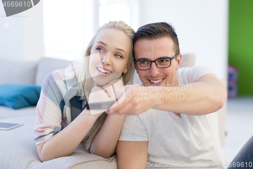 Image of Young couple on the sofa watching television