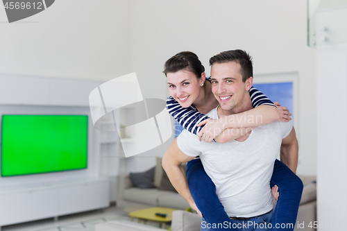 Image of handsome man piggybacking his girlfriend