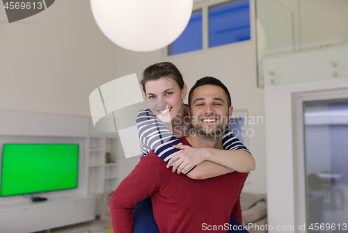 Image of handsome man piggybacking his girlfriend