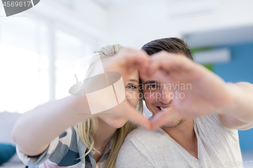 Image of couple making heart with hands