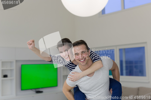 Image of handsome man piggybacking his girlfriend