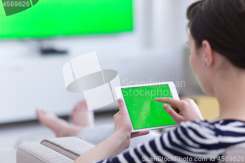 Image of woman on sofa using tablet computer