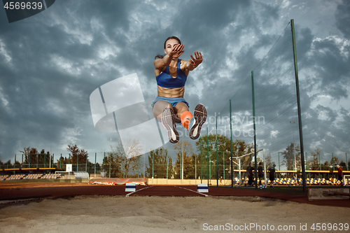 Image of Female athlete performing a long jump during a competition