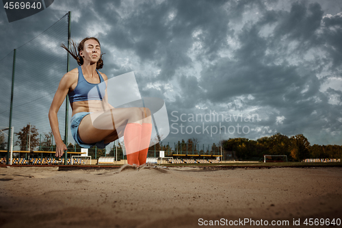 Image of Female athlete performing a long jump during a competition