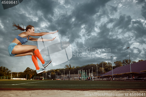 Image of Female athlete performing a long jump during a competition