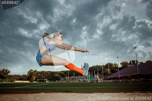 Image of Female athlete performing a long jump during a competition