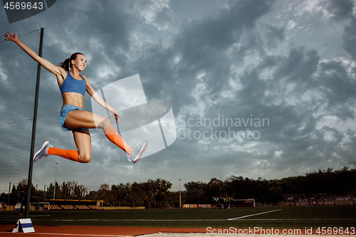 Image of Female athlete performing a long jump during a competition