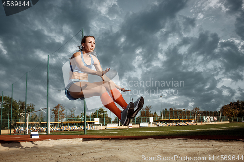 Image of Female athlete performing a long jump during a competition