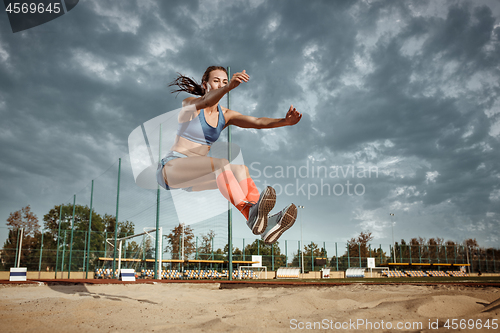 Image of Female athlete performing a long jump during a competition