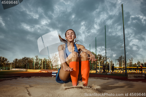 Image of Female athlete performing a long jump during a competition