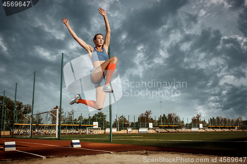 Image of Female athlete performing a long jump during a competition