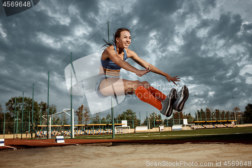 Image of Female athlete performing a long jump during a competition