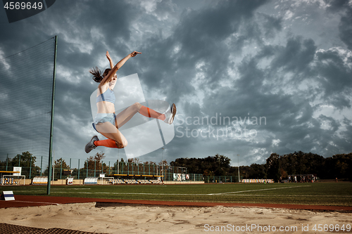 Image of Female athlete performing a long jump during a competition