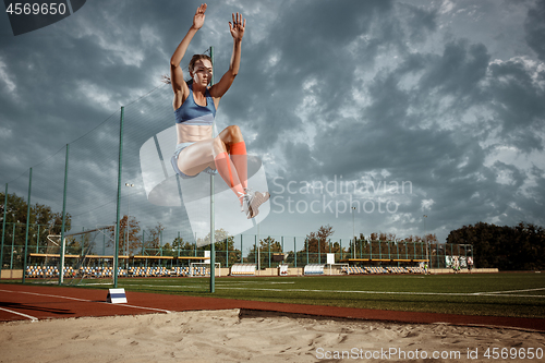 Image of Female athlete performing a long jump during a competition