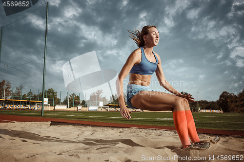 Image of Female athlete performing a long jump during a competition