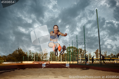 Image of Female athlete performing a long jump during a competition