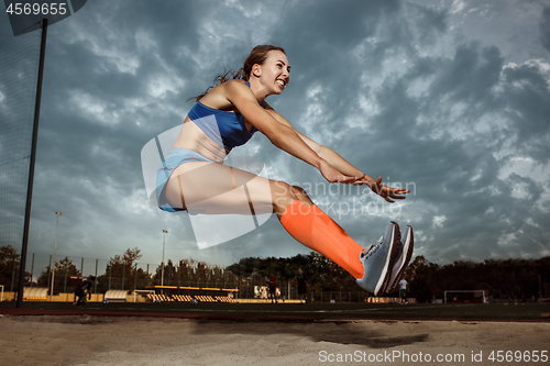 Image of Female athlete performing a long jump during a competition