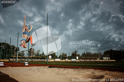 Image of Female athlete performing a long jump during a competition