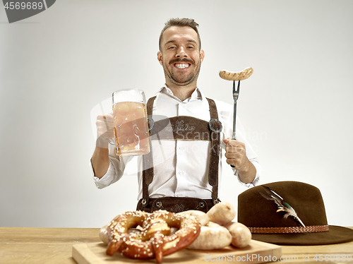 Image of Germany, Bavaria, Upper Bavaria, man with beer dressed in traditional Austrian or Bavarian costume