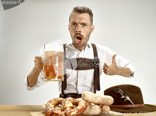 Image of Germany, Bavaria, Upper Bavaria, man with beer dressed in traditional Austrian or Bavarian costume