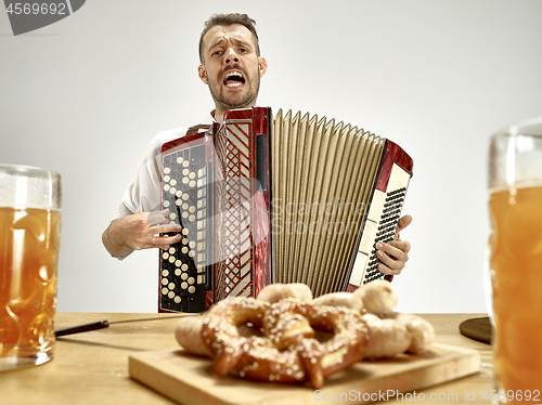 Image of Man in traditional bavarian clothes playing accordion. Oktoberfest