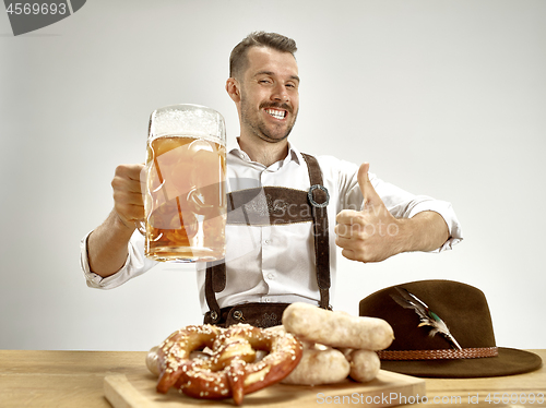 Image of Germany, Bavaria, Upper Bavaria, man with beer dressed in traditional Austrian or Bavarian costume