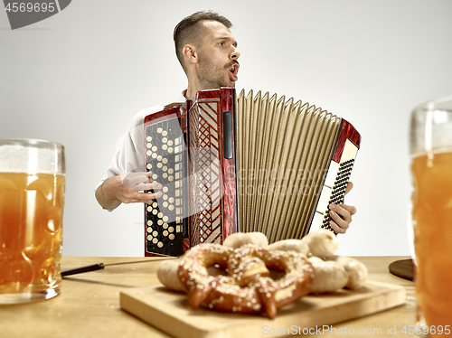 Image of Man in traditional bavarian clothes playing accordion. Oktoberfest