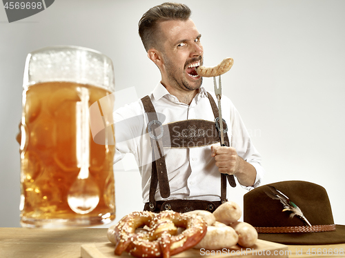 Image of Germany, Bavaria, Upper Bavaria, man with beer dressed in traditional Austrian or Bavarian costume