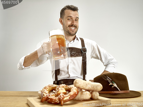 Image of Germany, Bavaria, Upper Bavaria, man with beer dressed in traditional Austrian or Bavarian costume