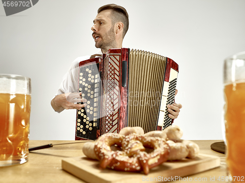 Image of Man in traditional bavarian clothes playing accordion. Oktoberfest