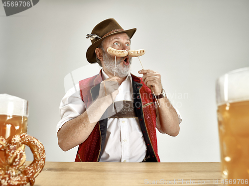 Image of Germany, Bavaria, Upper Bavaria, man with beer dressed in traditional Austrian or Bavarian costume